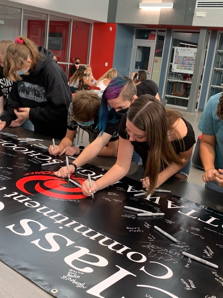 students signing a poster 