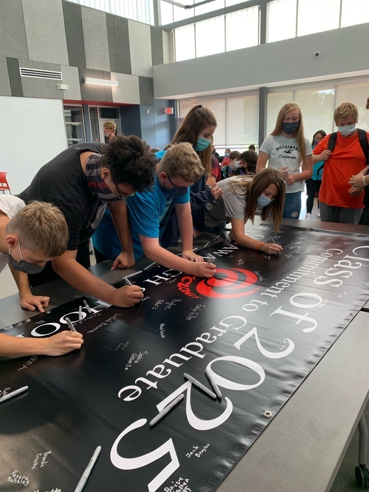 students signing a poster 