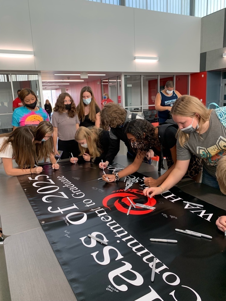 students signing a poster 