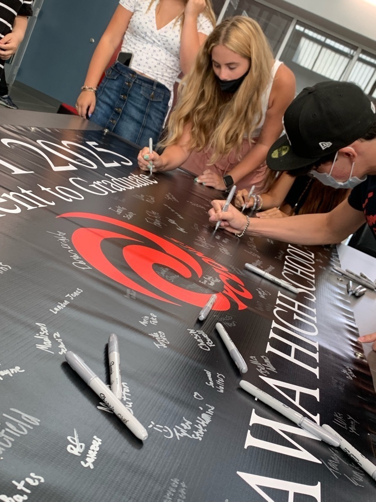 students signing a poster 