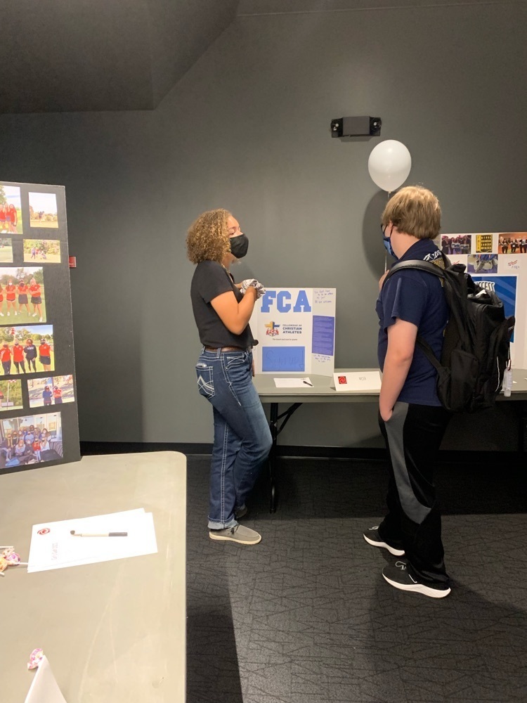 student explaining a club to another student 