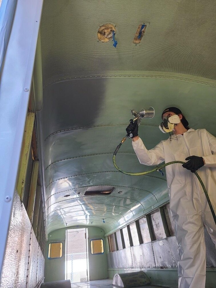 student spraying the inside of a bus