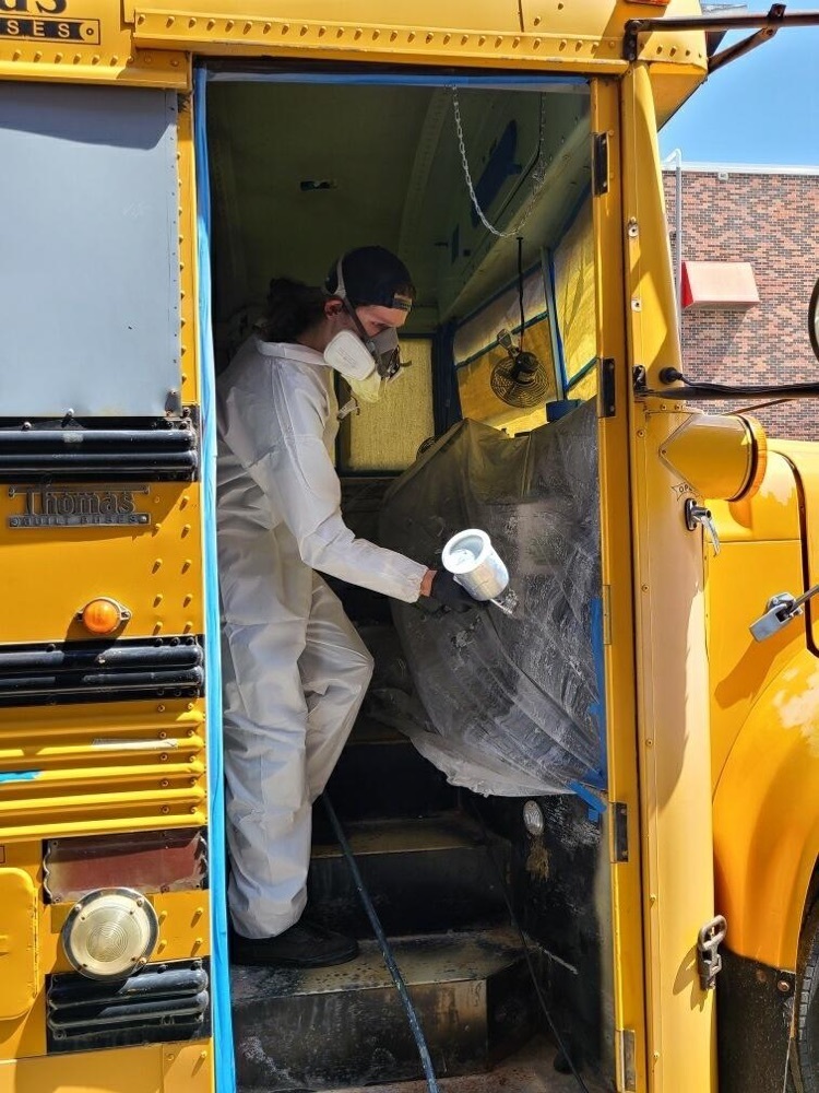 student spraying the inside of the bus