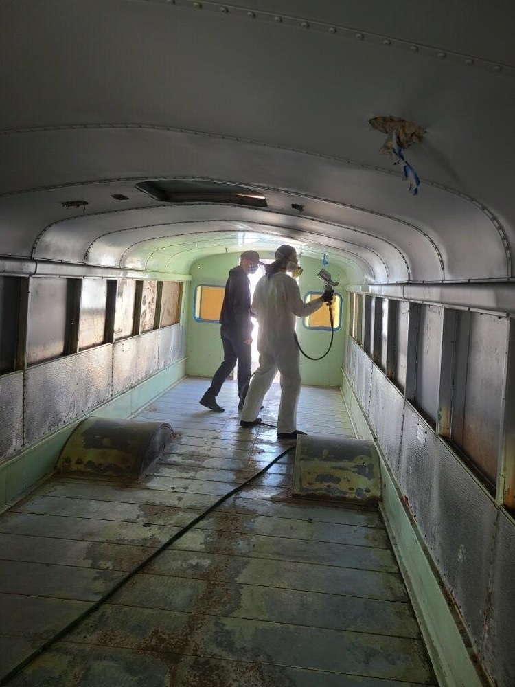 student spraying the inside of a bus