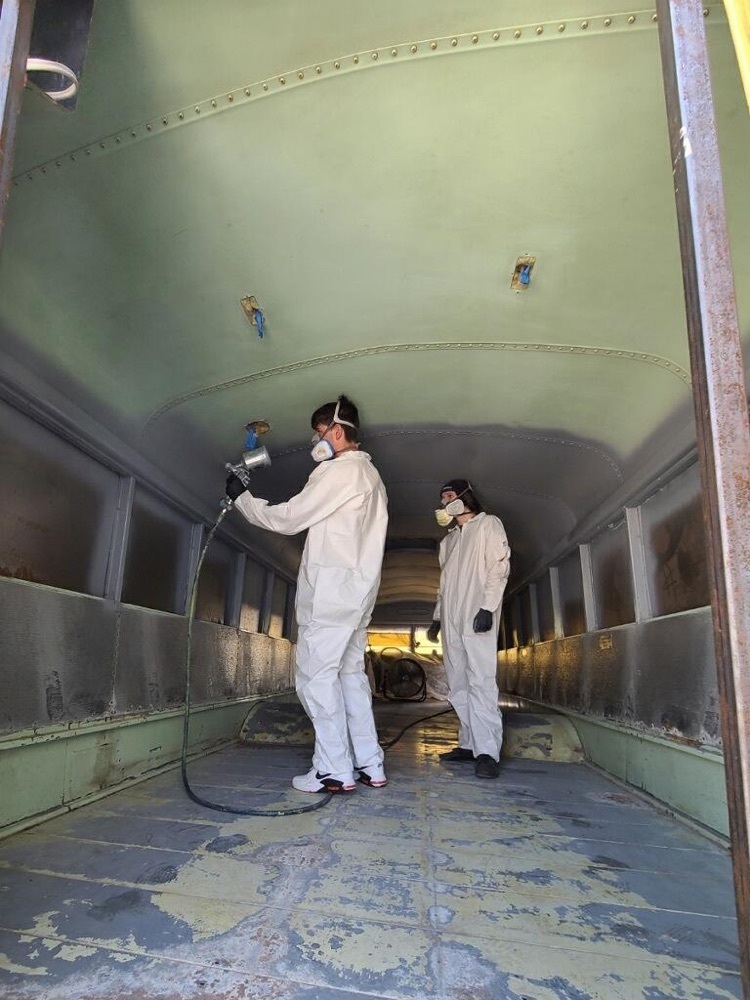 students spraying the inside of a bus