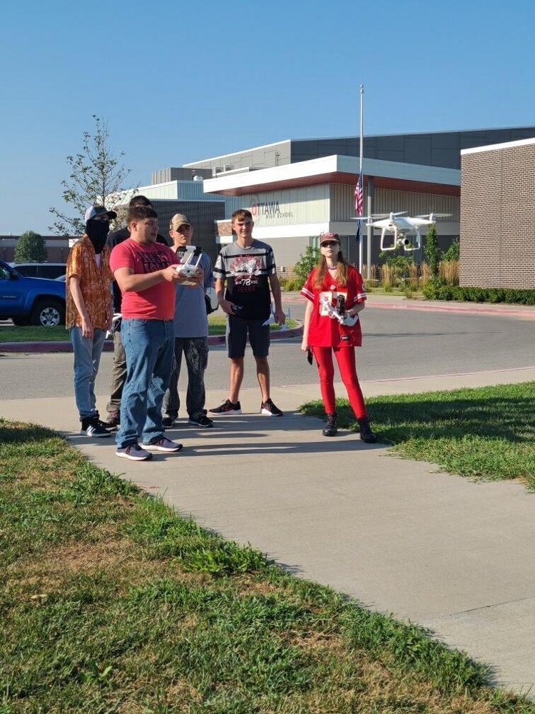 teacher with students and a drone
