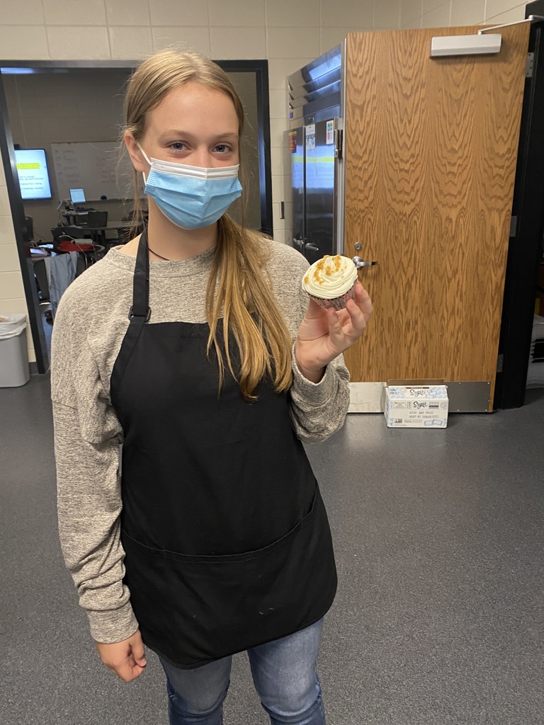 Student holding finished cupcake
