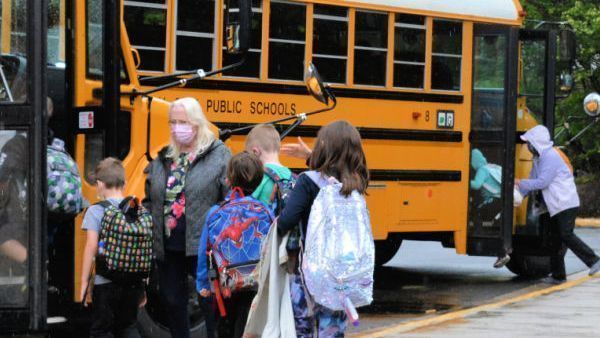 students getting on school buses