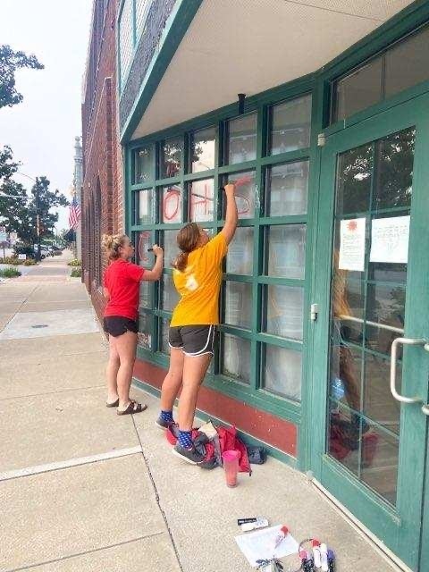 girls painting windows 