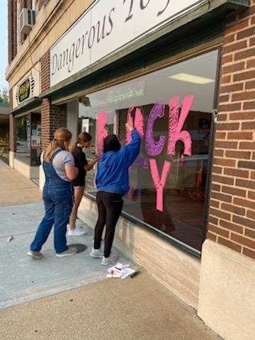 girls painting windows 