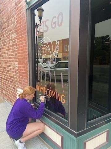 girls painting a window 