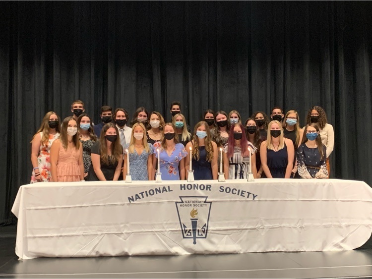 students posing behind a table 