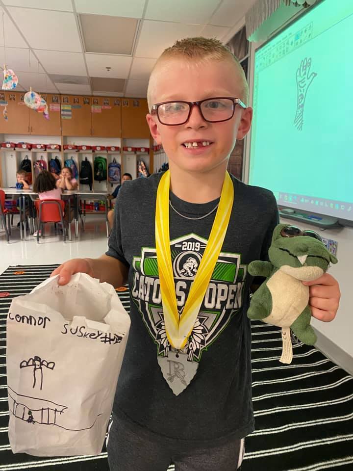 student with medal & stuffed animal