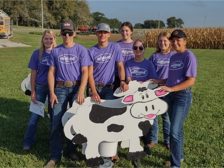 students standing by a cow