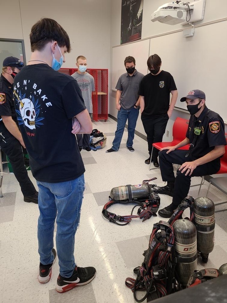 students looking at fire gear 