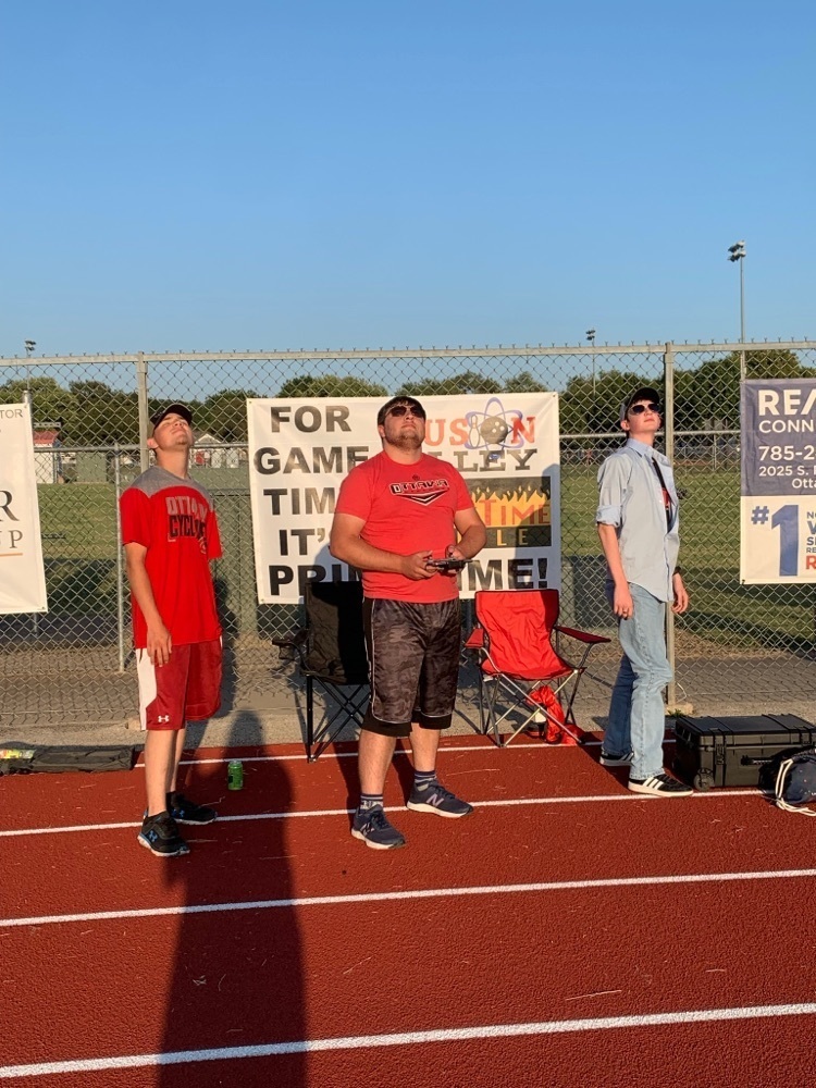 three people standing with a Drone 
