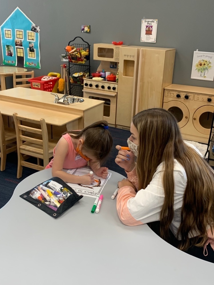 preschool student working with high schooler 