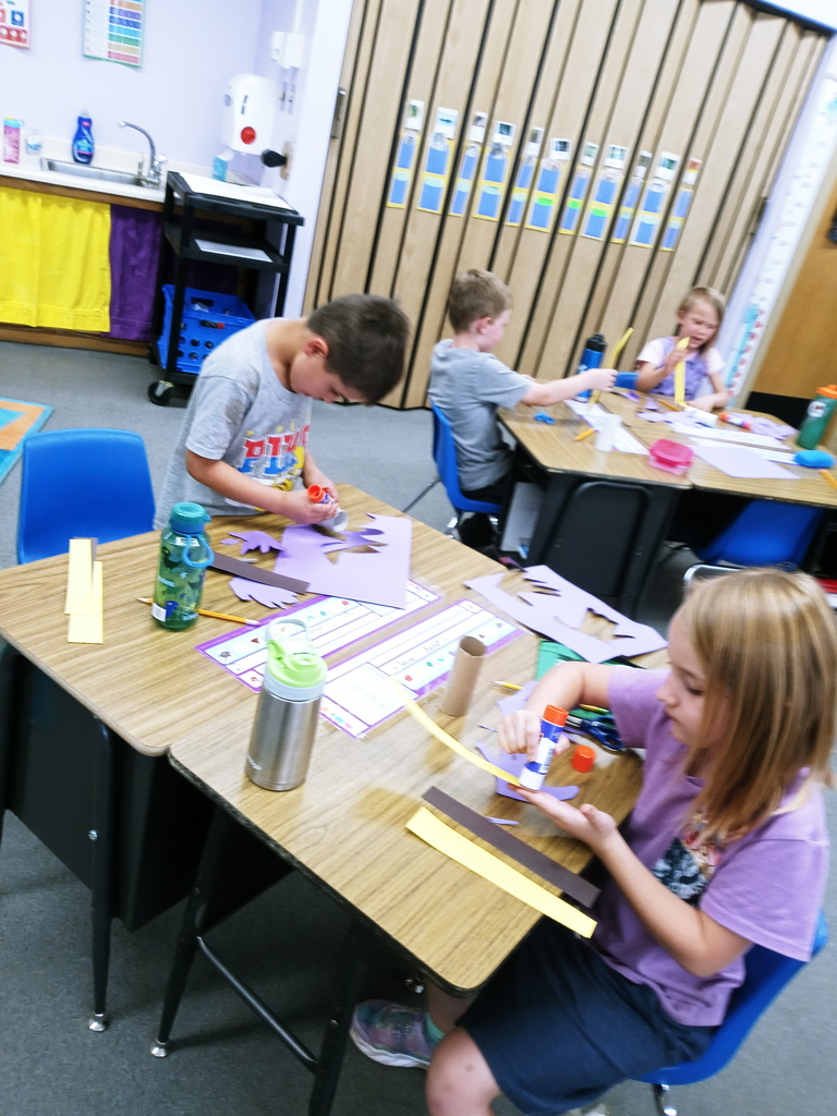 First graders gluing their bees together.