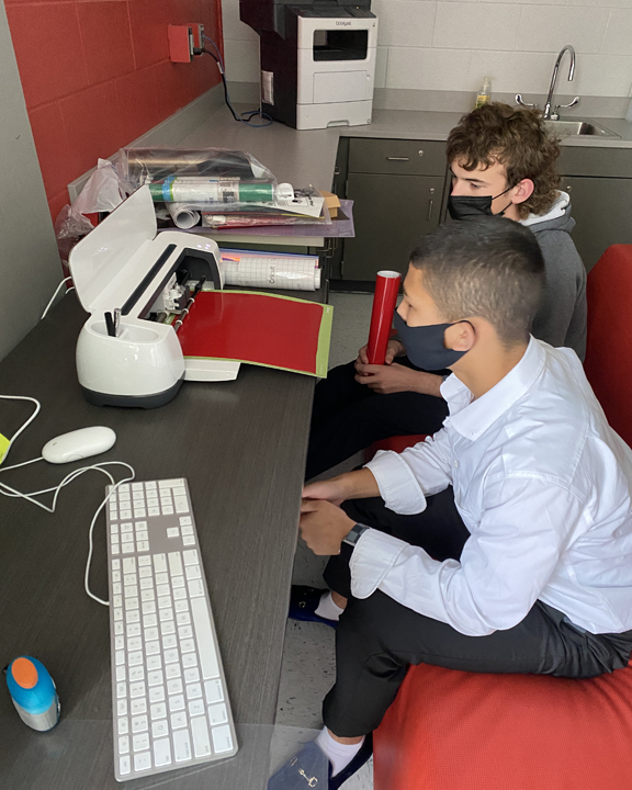 two students using a cricut