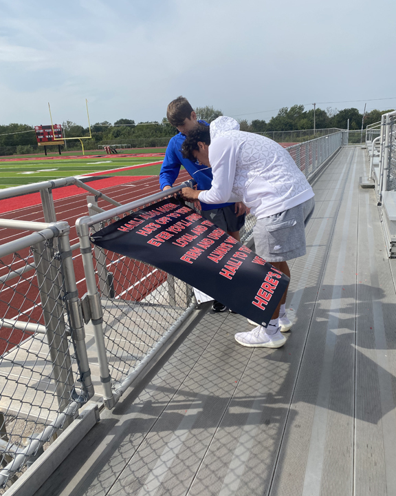 student hanging up a banner