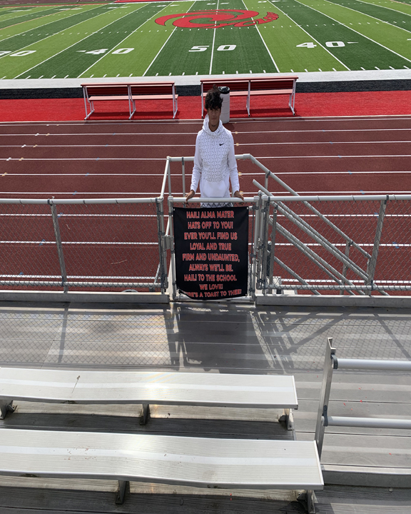 student posing with a banner