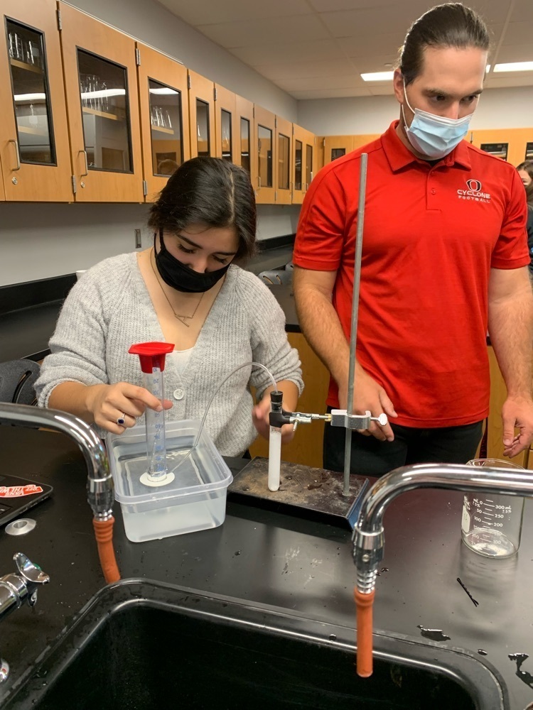 students doing a lab and teacher giving feedback