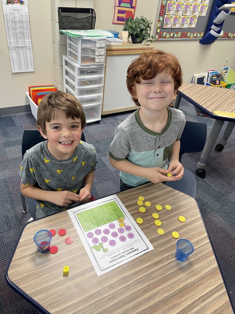 two boys sitting a desk with red and yellow chips