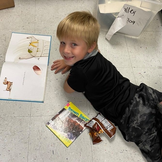 boy reading with cookie snack 