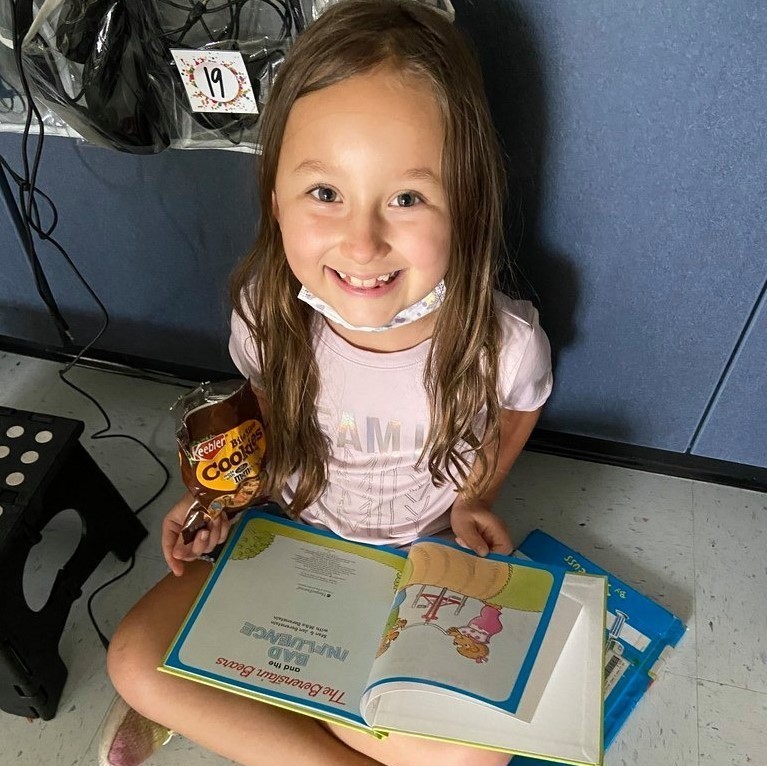 girl reading with cookie snack