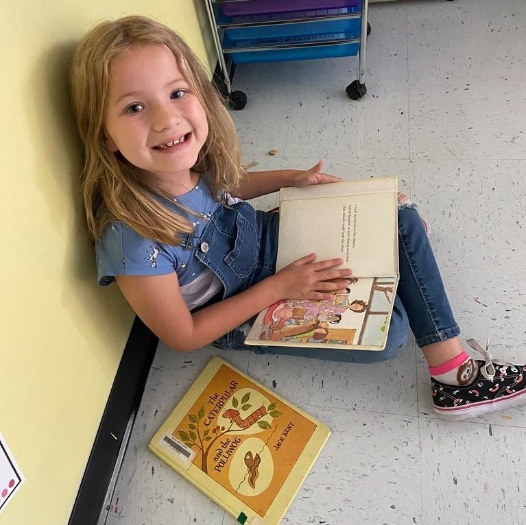 girl reading with cookie snack 