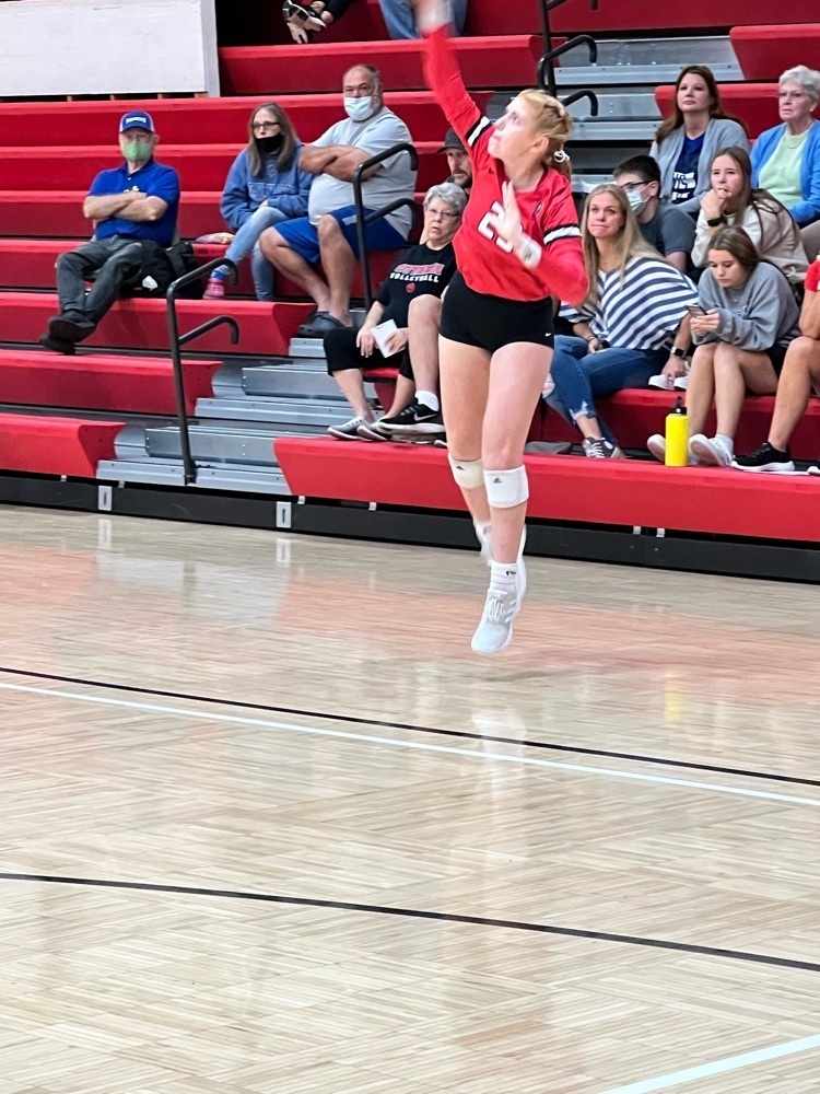 girl serving a volleyball 