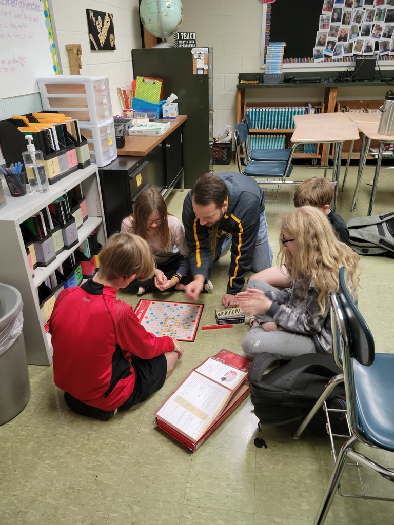 Students and principal playing Scrabble