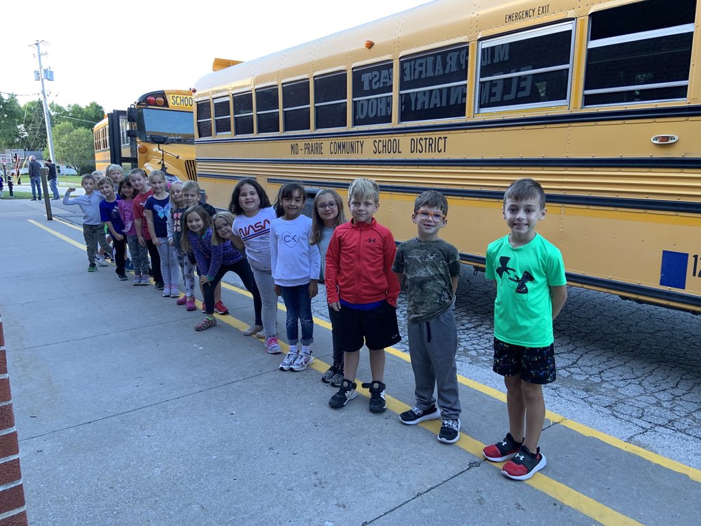 Students lined up by a bus