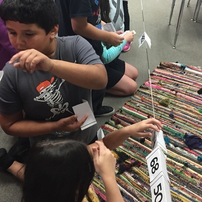 student helping other student with the ordering of numbe ron the string 