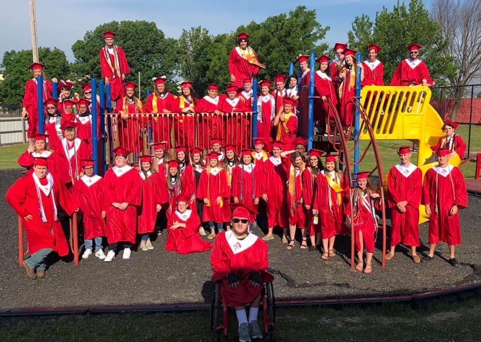 STUDENTS IN GRADUATION GOWNS ON PLAYGROUND