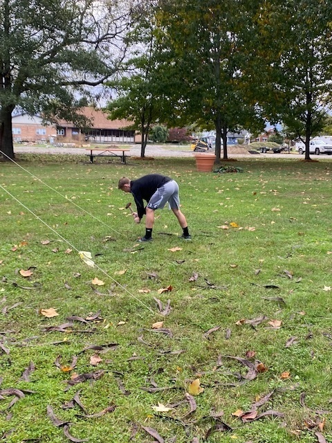 Student pounding stakes