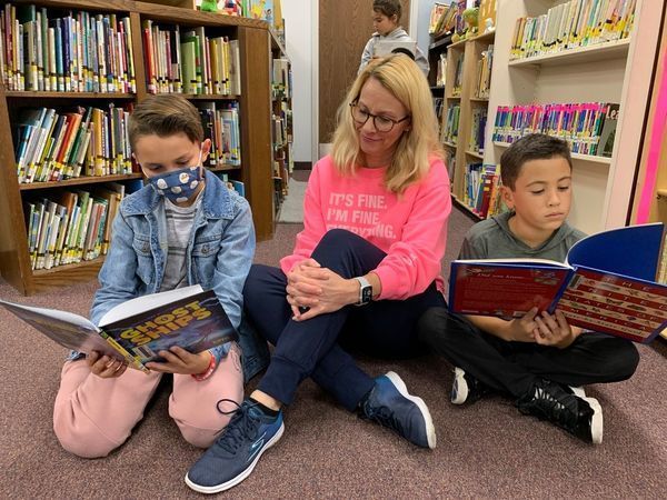 teacher & students in sweats reading