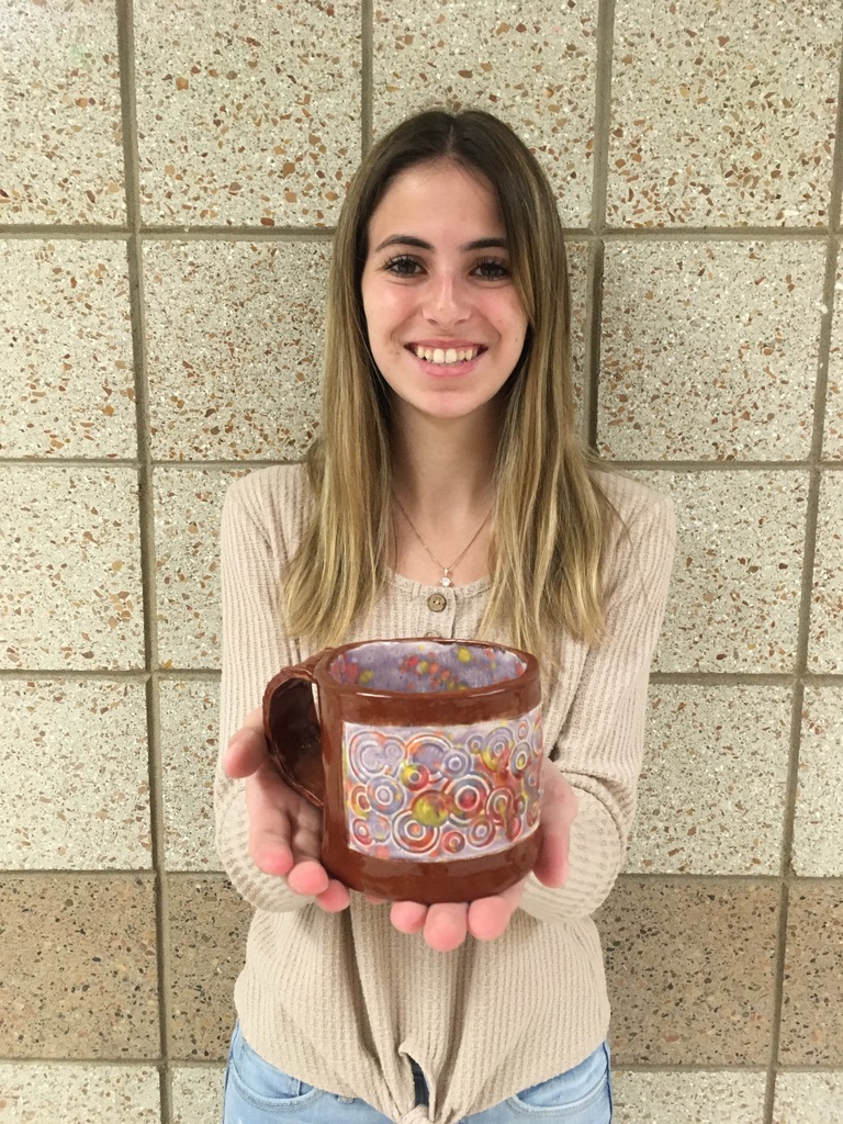 female holding a homemade mug