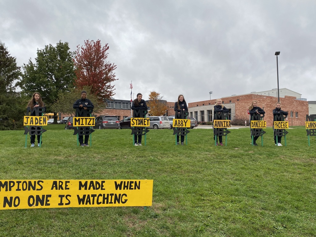 Girls cross country team by signs