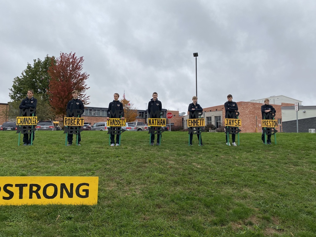 Boys cross country team by signs