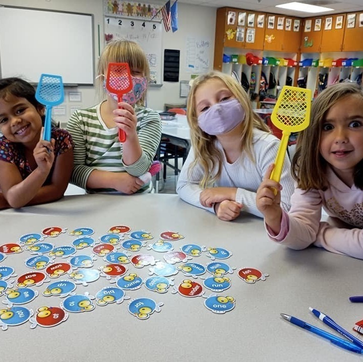 girls with swatters and cards on table