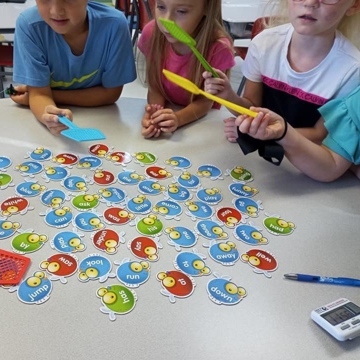 kids with swatters and cards on table