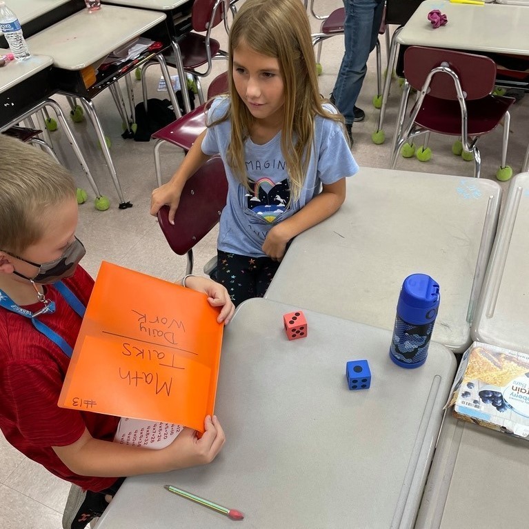 boy & girl with math facts folder and dice