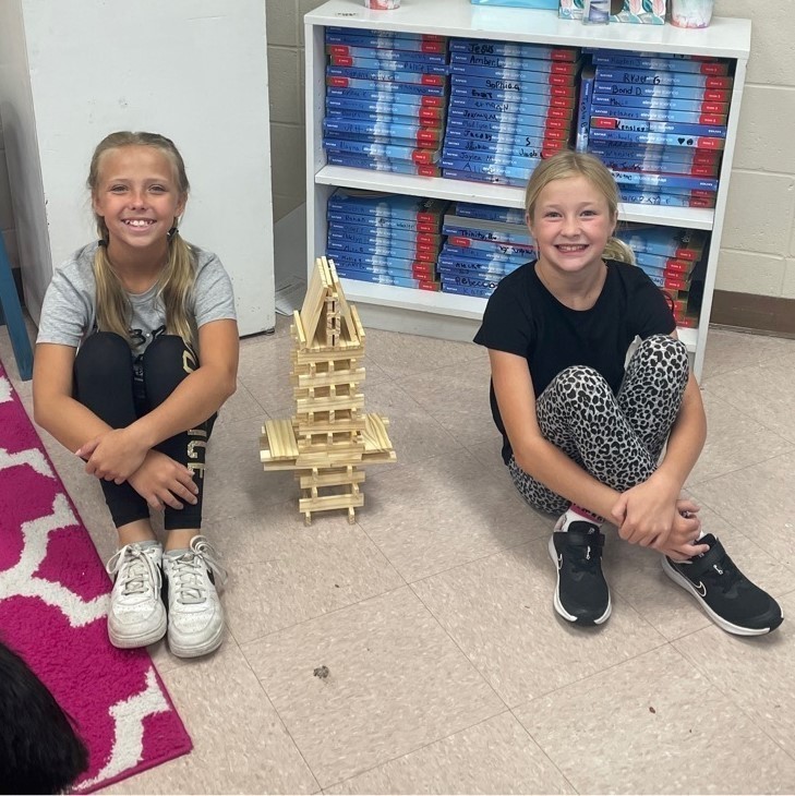 two girls building a tower