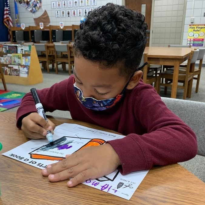 boy coloring with black marker