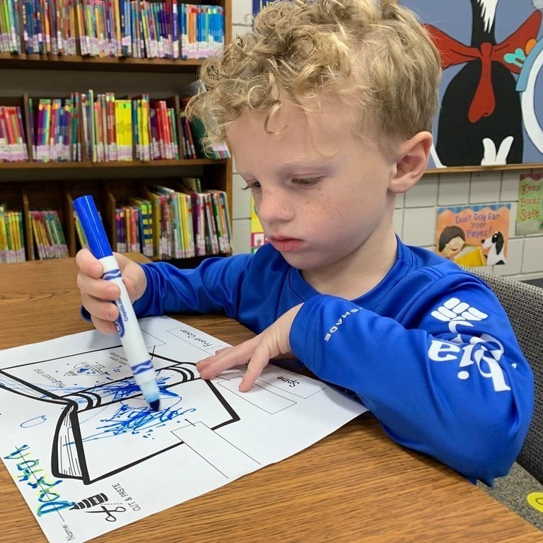 boy coloring with blue marker