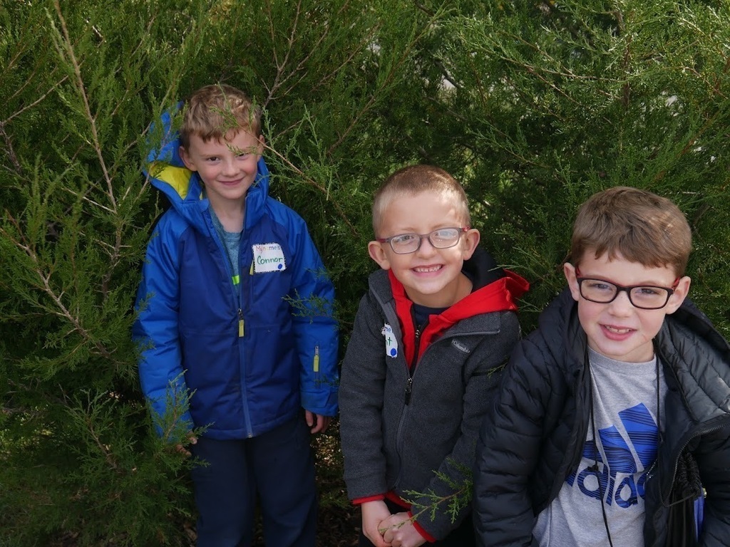 Three boys hiding in the woods.