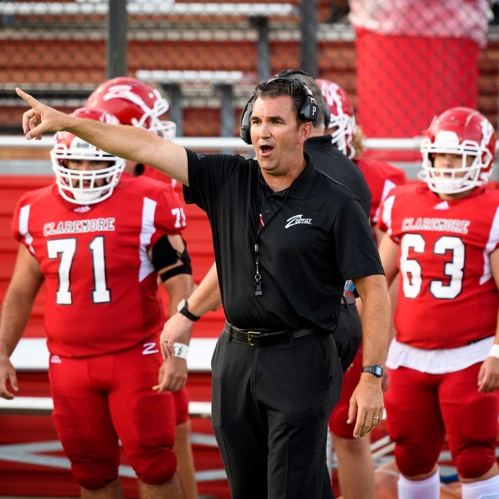 Coach hurt on sidelines with player pointing.  Photo Credit:  Means Photography 