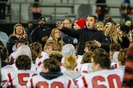 Coach hurt in the huddle with player pointing. Photo Credit: Claremore Progress