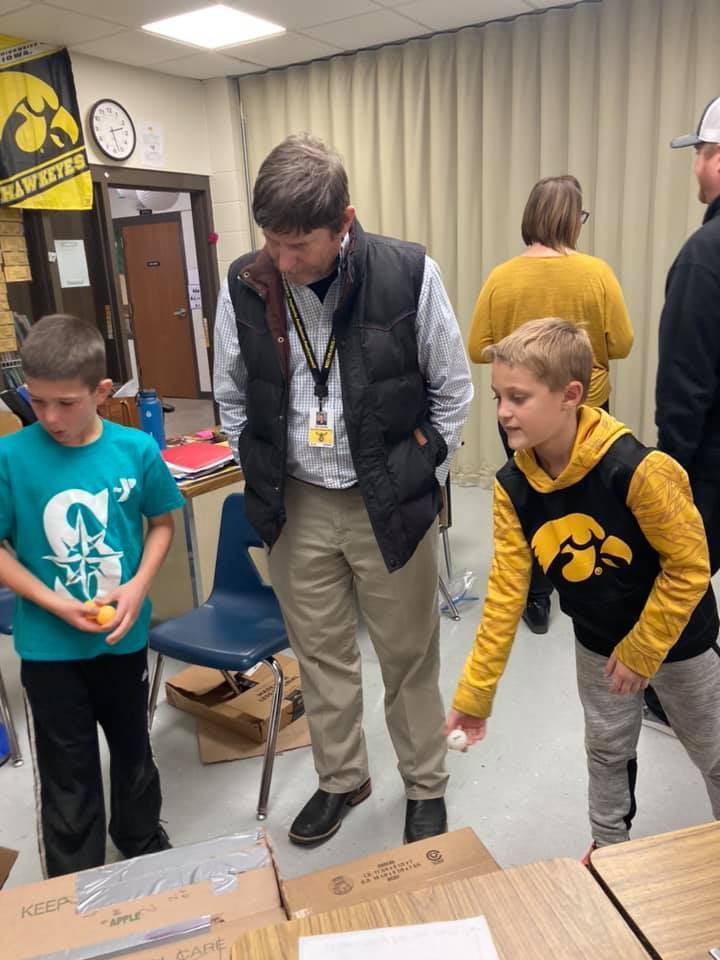 Students showing Mr. Schneider their cardboard game